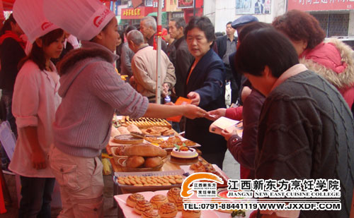 社區(qū)居民在領取江西新東方西式面點專業(yè)的宣傳品