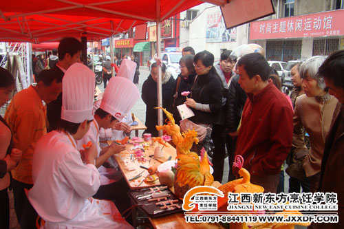 江西新東方學員的食品雕刻技術展示受到社區(qū)居民的圍觀