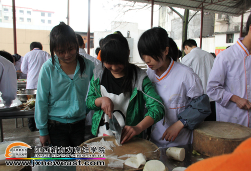 學(xué)生在<a href=http://www.8881133.com target=_blank class=infotextkey>江西新東方烹飪學(xué)院</a>學(xué)姐的指導(dǎo)下體驗(yàn)刀工