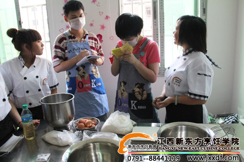 <a href=http://www.8881133.com target=_blank class=infotextkey>江西新東方烹飪學(xué)院</a>的學(xué)生仔細(xì)給孩子們講解做蛋糕的知識(shí)~.jpg